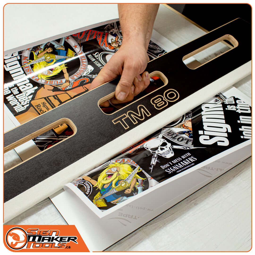 Hand using TimberMaxx TM 80 squeegee to apply large-format graphics to a flat surface