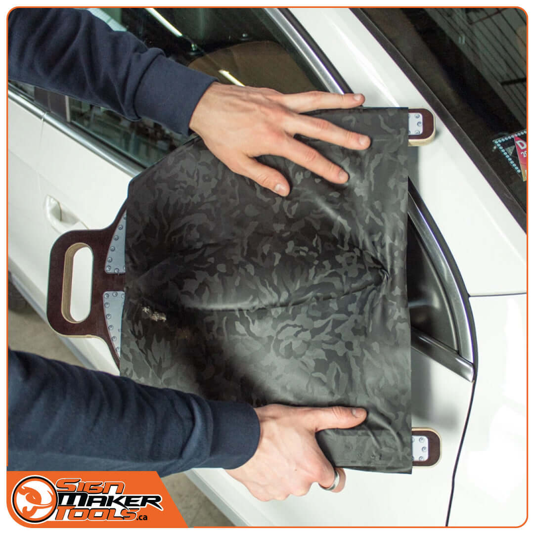 Smoothing vinyl with the Wrap-U-Ezee ring on a car mirror