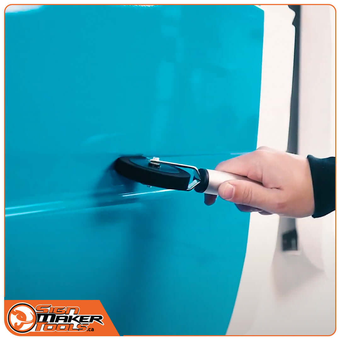 Applying vinyl with Yellotools pressure roller on blue structured surface