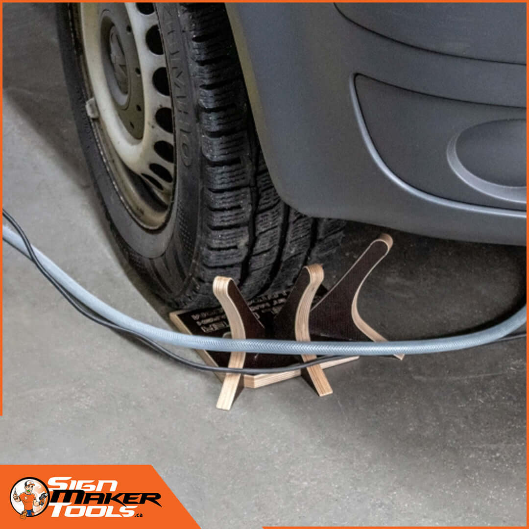 Cable Flyer in use preventing cables and hoses from being pinched under a car wheel
