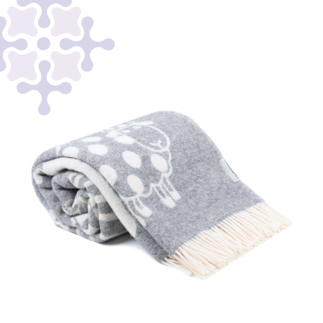 Rolled sheep-patterned wool throw blanket with cream fringe and decorative corner design