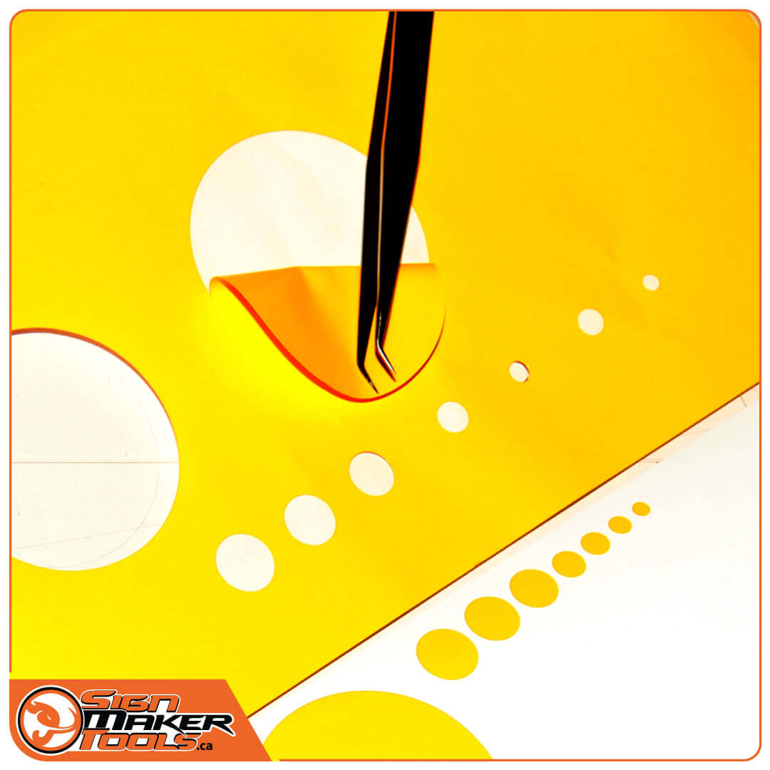 Precision cut circles in yellow sheet made with SensorCut Orbit, tweezers lifting a circle