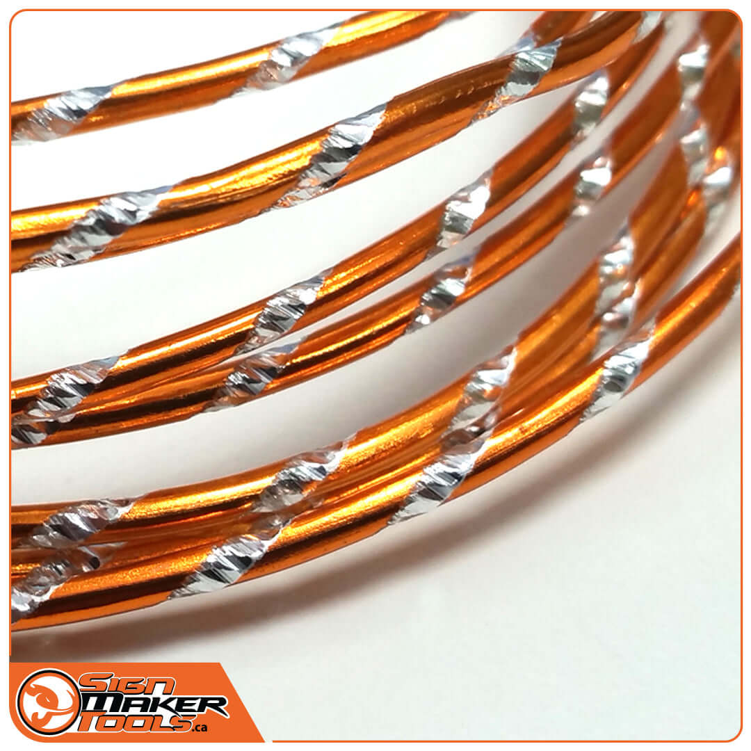 Close-up of orange anodized aluminum WrapBend-it wire with silver spiral accents