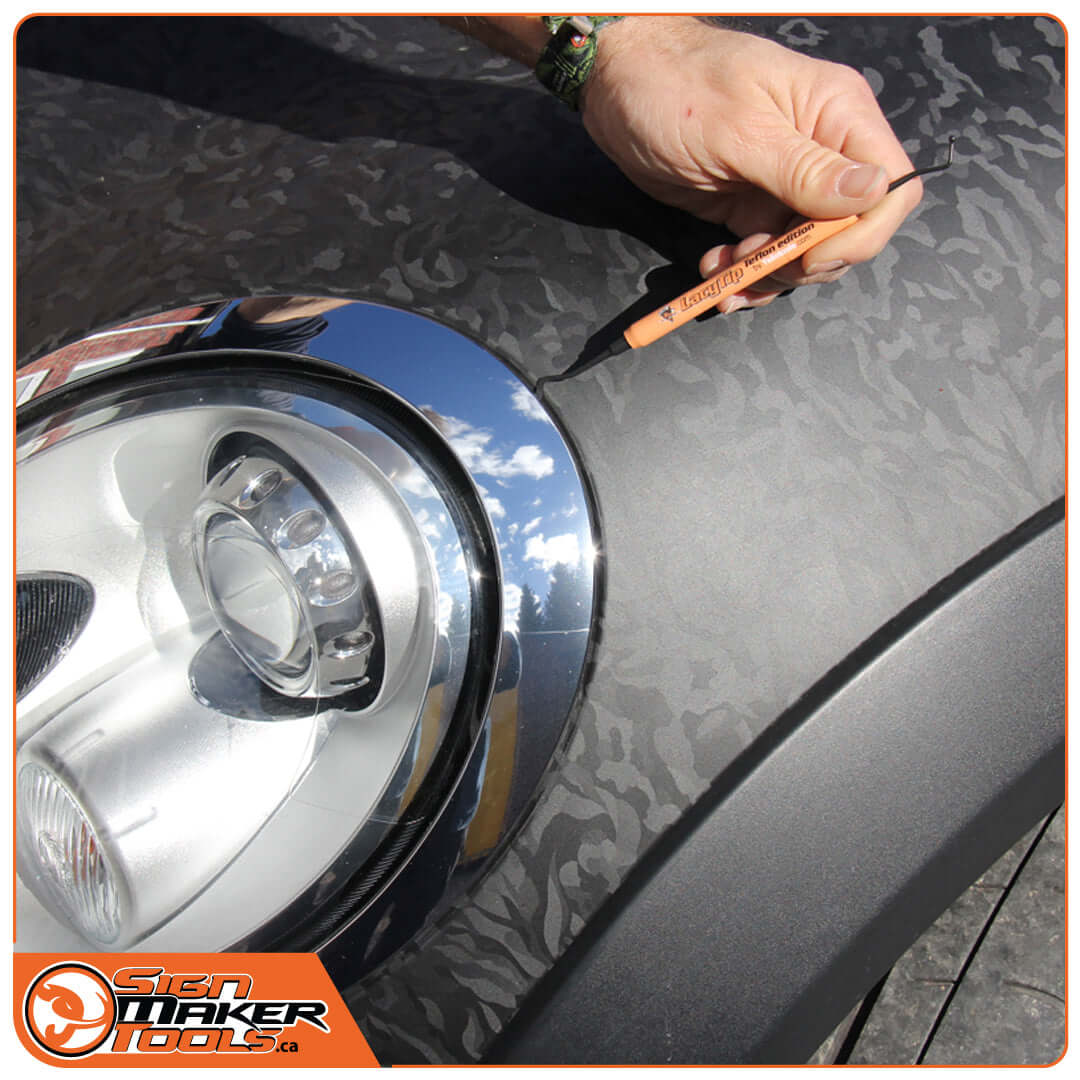 Professional using LacyTip Teflon tool for vinyl wrap around a car headlight