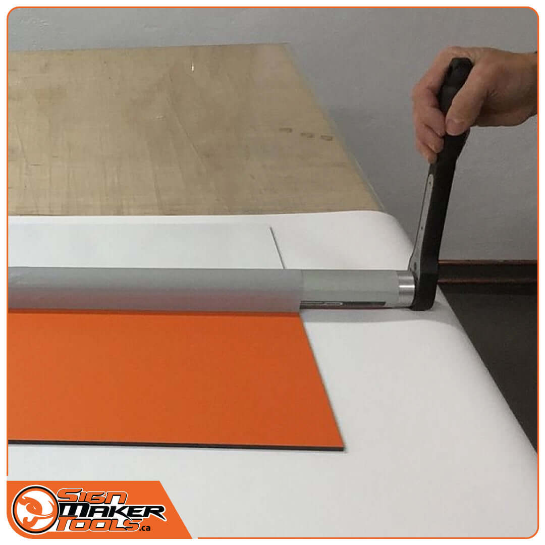 Operating the RapidRemover tool with a ratchet to remove vinyl from an orange sign board