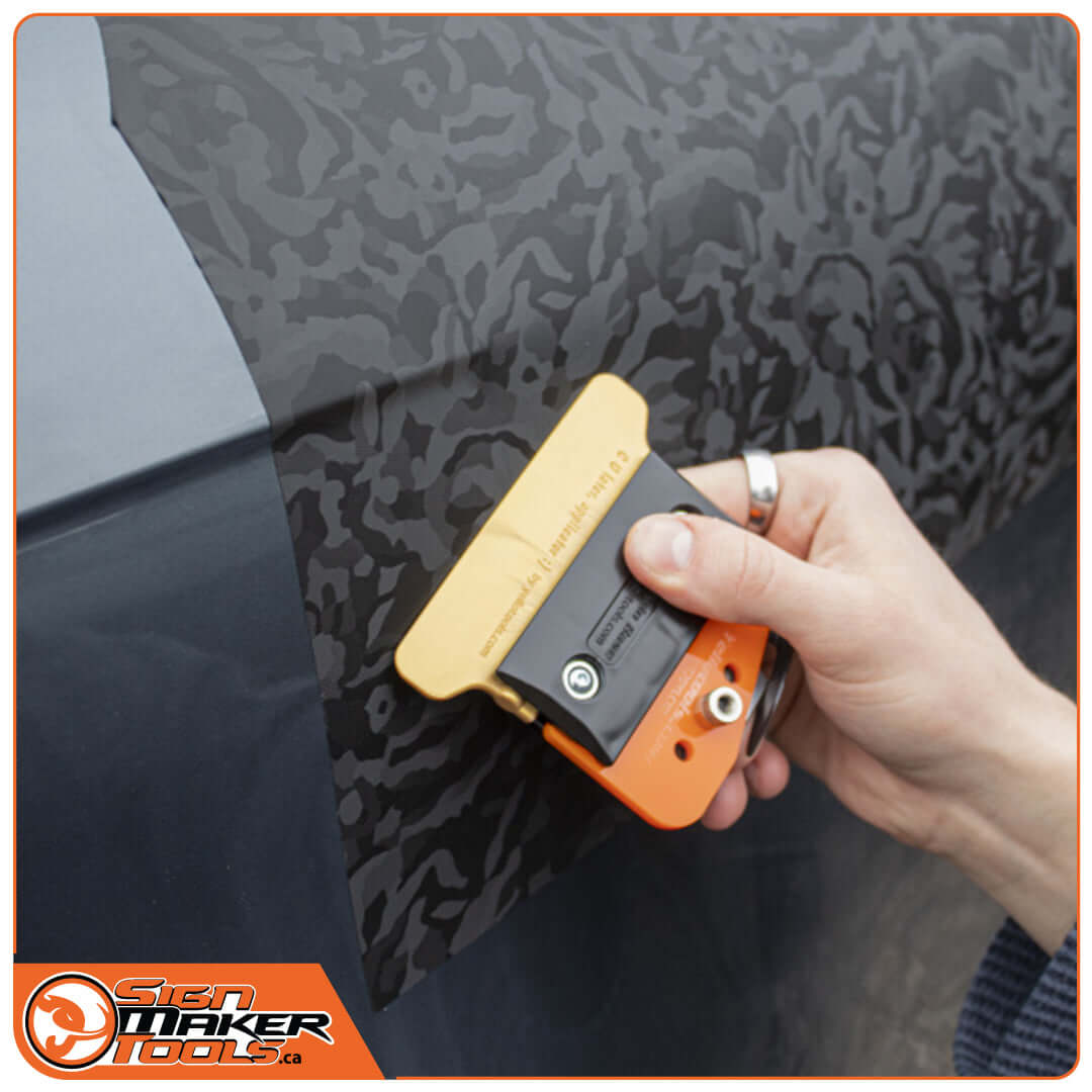 Smoothing vinyl wrap on car with YelloTwin squeegee knife insert
