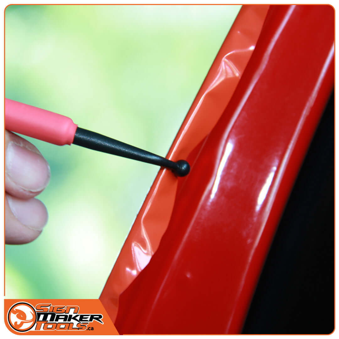 Using the LacyTip HD to tuck red vinyl underneath a car trim edge
