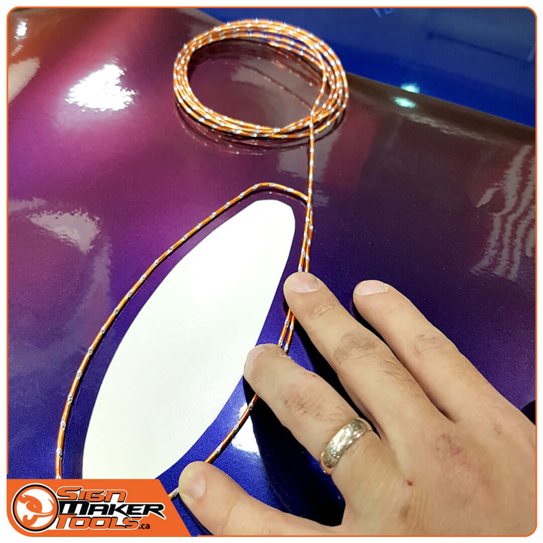 Tracing an irregular shape on a purple car hood using flexible WrapBend-it contour wire
