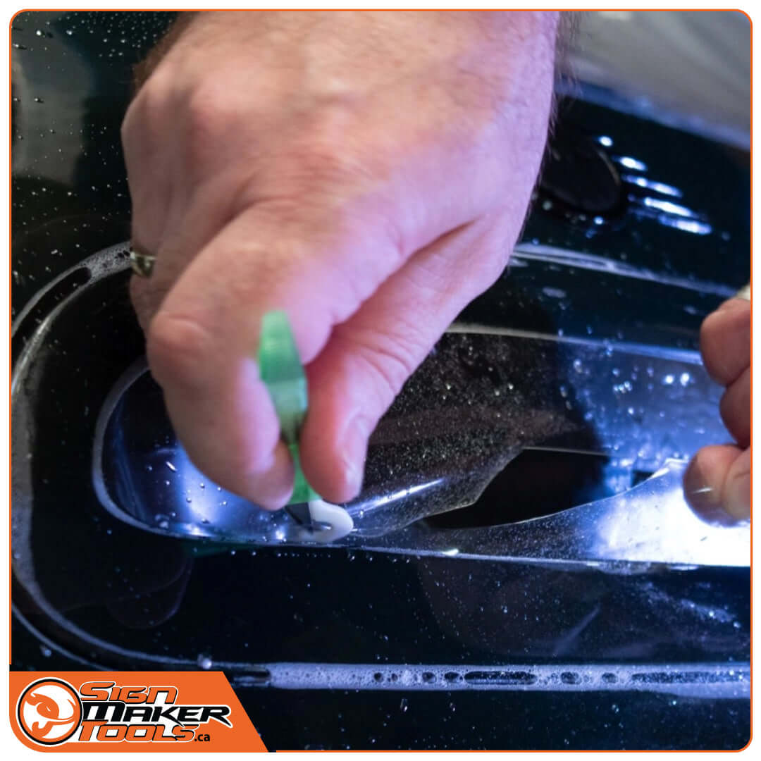 Using WrapDefender vinyl cutter for precise film application on a car door handle