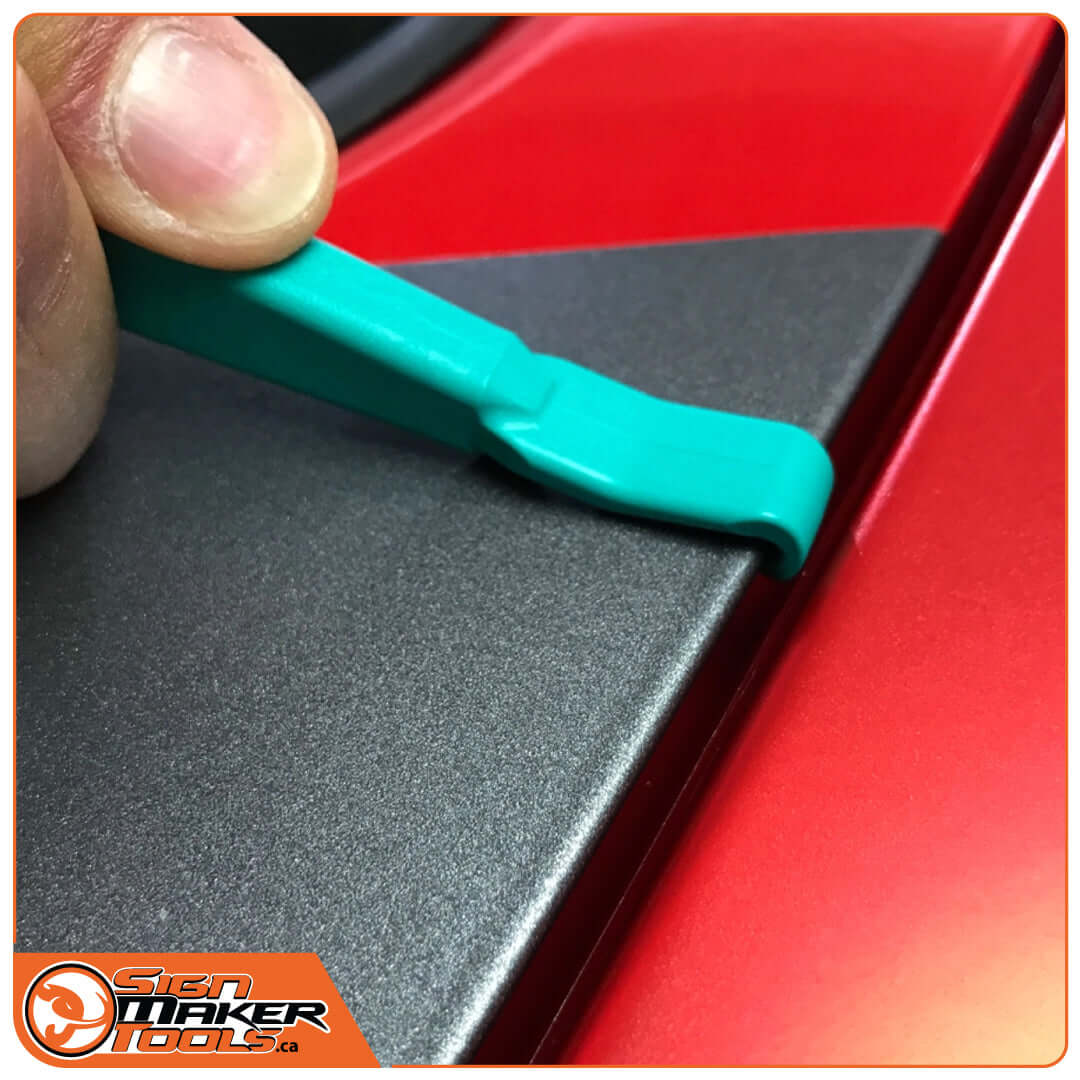 Closeup of WrapStick Hook maneuvering vinyl into a narrow vehicle detail