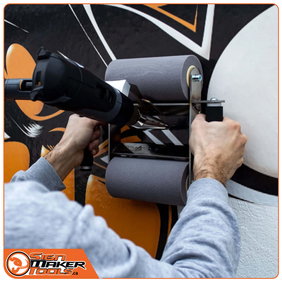 Person operating WallRoller HOT on a mural with a Steinel heat gun attached