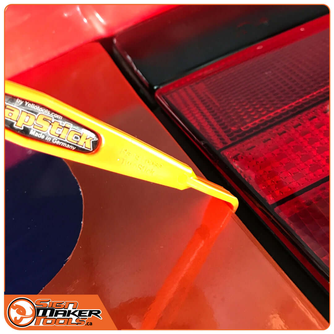 WrapStick HangLoose being used to fit vinyl around tight gaps near car taillight