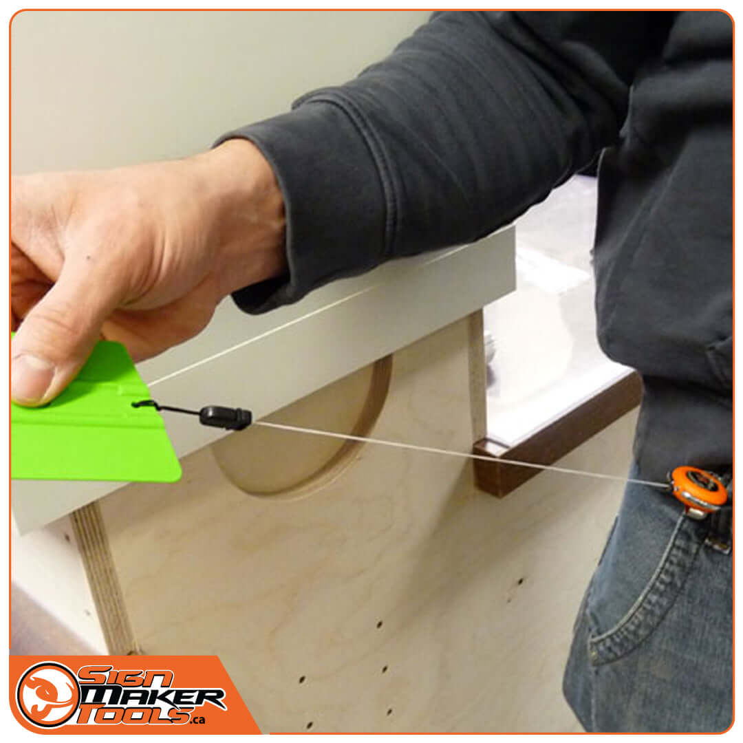 Using the EasyCord to keep a green squeegee accessible on a tool belt