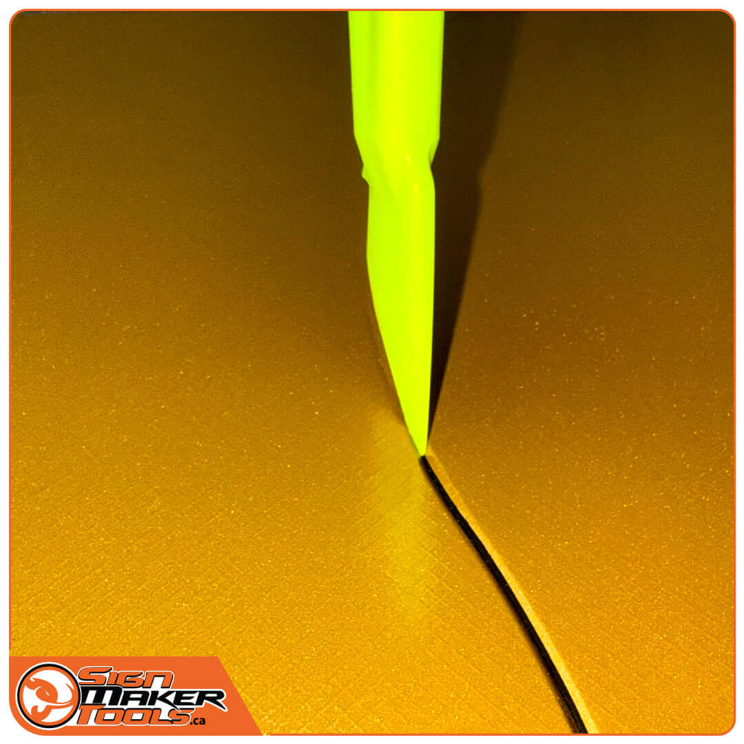 GoliaCut Stick making a precise cut through gold vinyl material