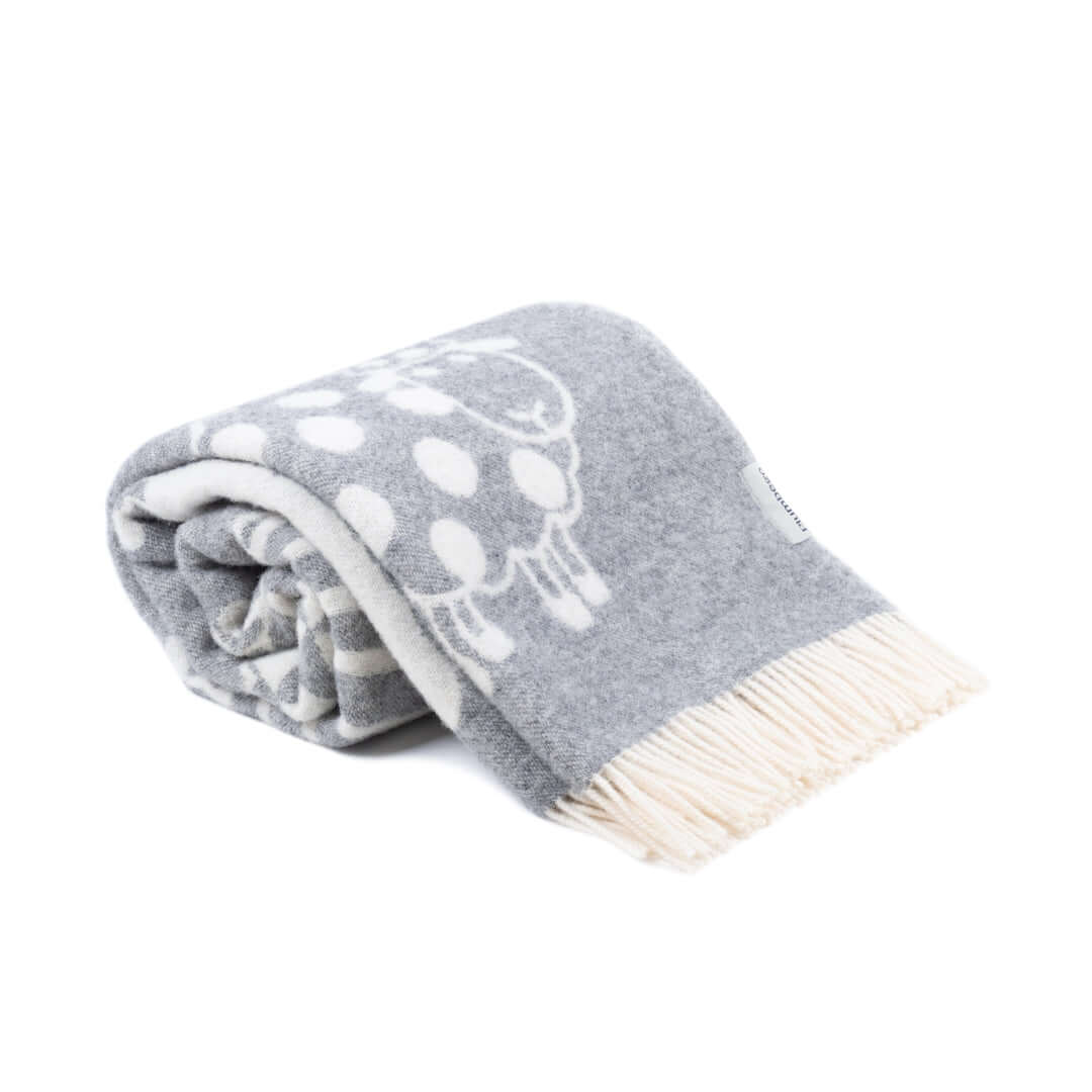 Rolled grey wool throw blanket with whimsical white sheep patterns and creamy fringe