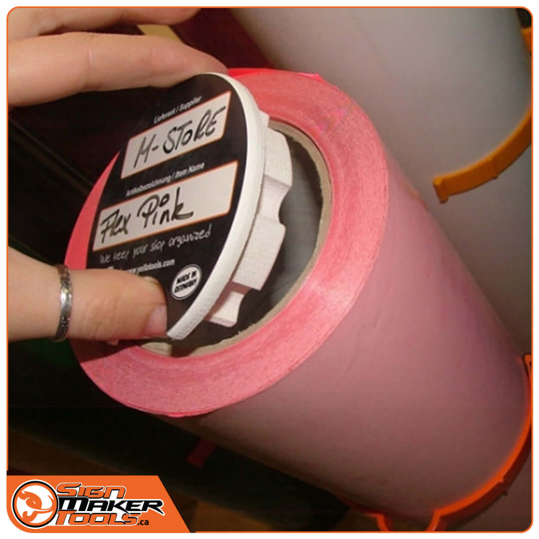 Hand inserting MediaLids organizer lid labeled 'Flex Pink' into a pink vinyl roll core