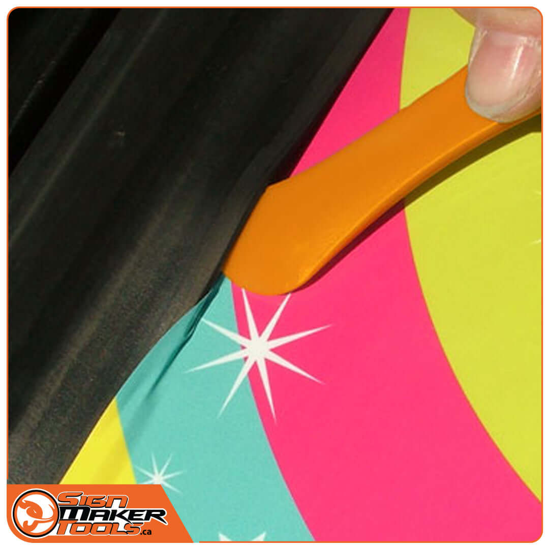 Inserting vinyl wrap into a groove with the RubberLift tool under rubber gasket