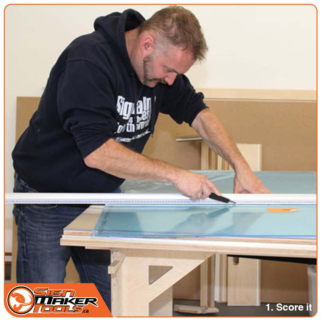 Man scoring a sheet of plexiglass using the P-Glass Twin tool and a ruler