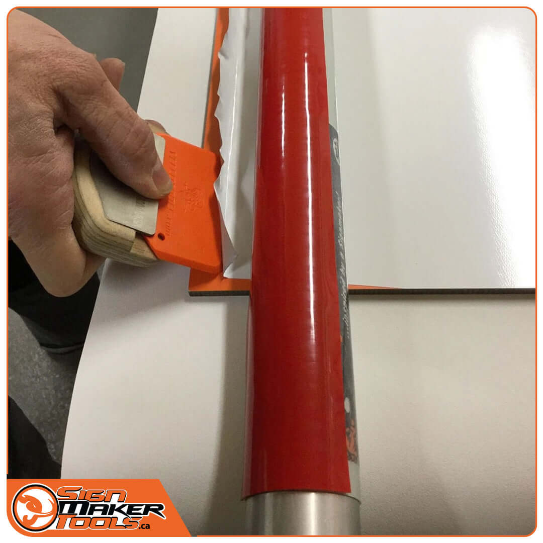 Using a scraper alongside the RapidRemover tool to peel vinyl from a sign