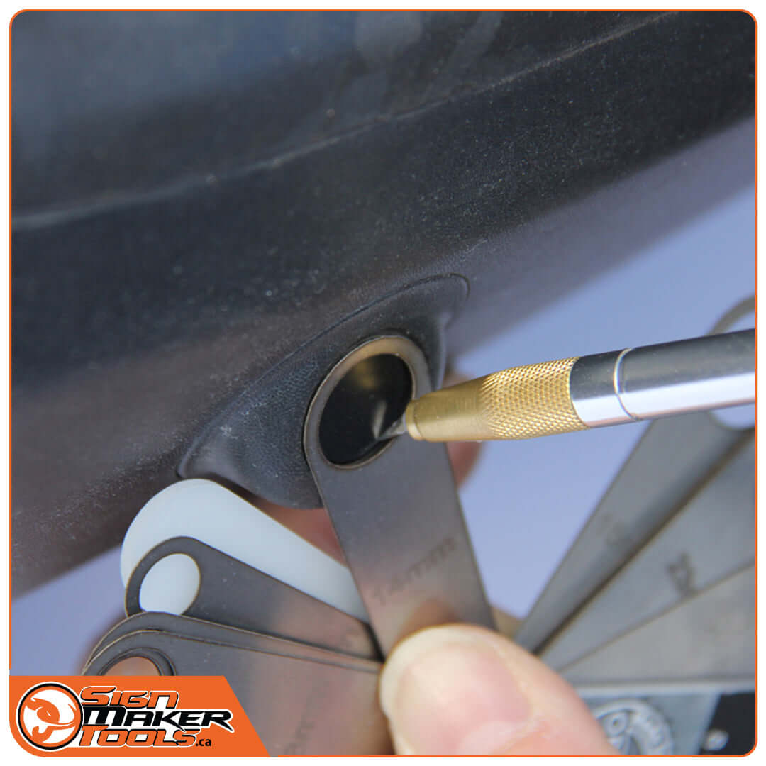 Aligning Sensor Cut Flexi blade on a car bumper parking sensor with a scribing tool