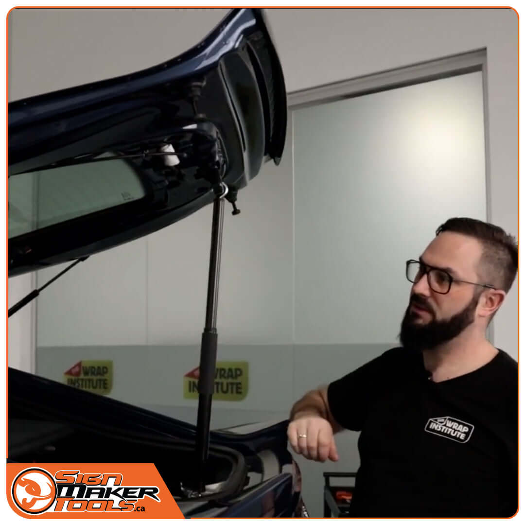 Person demonstrating the YelloOpen prop tool holding a car trunk open